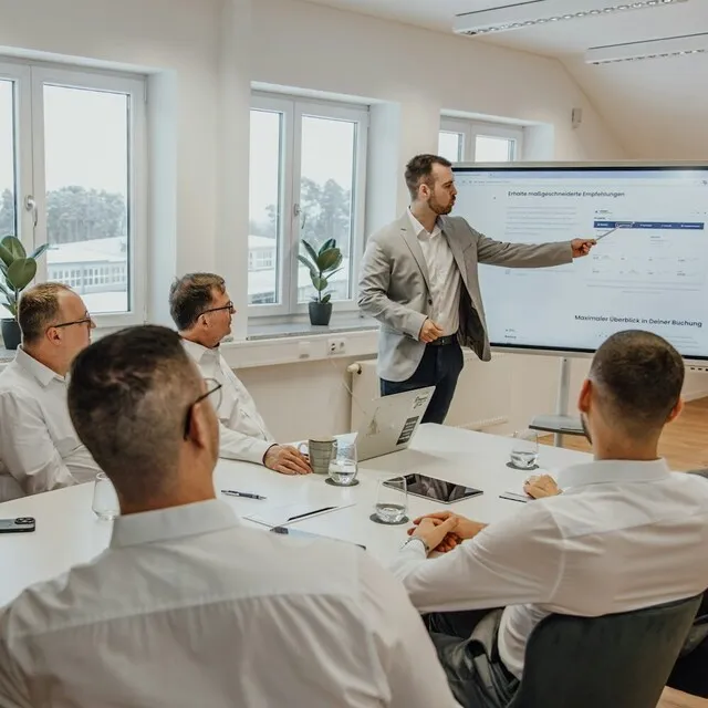 Grupo de pessoas em uma apresentação corporativa com gráficos